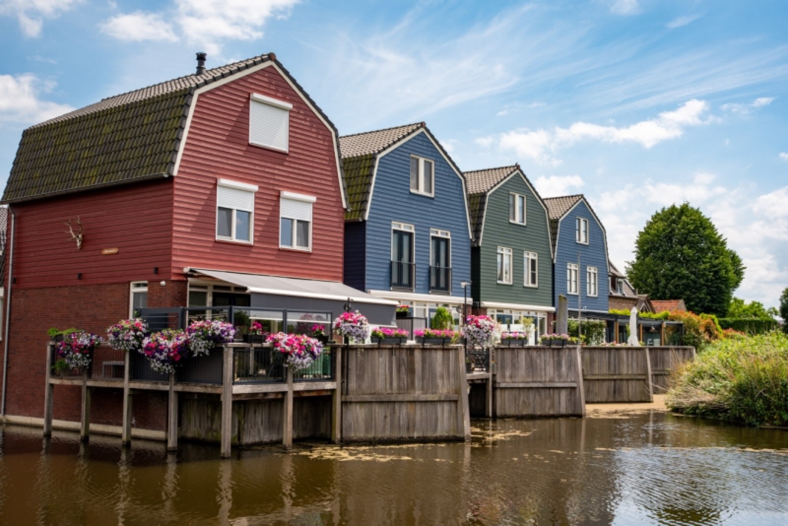Kleurrijke traditionele vissershuisjes aan het water in Spakenburg — rood, blauw en groen aan de kade